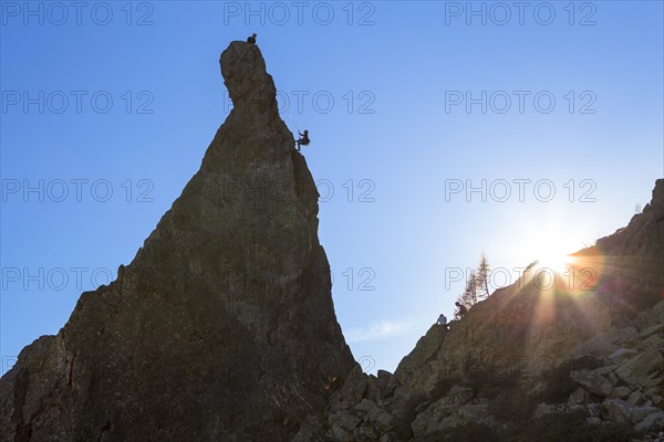 Climber abseiling off rocky pinnacle