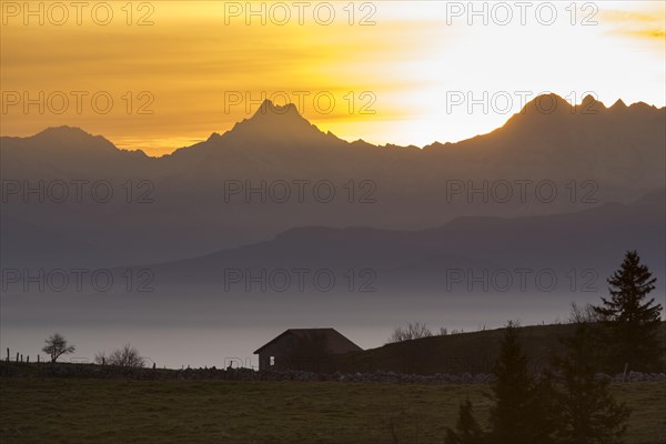 A cabin on the Creux du Van at sunrise overlooking the mountains Schreckhorn