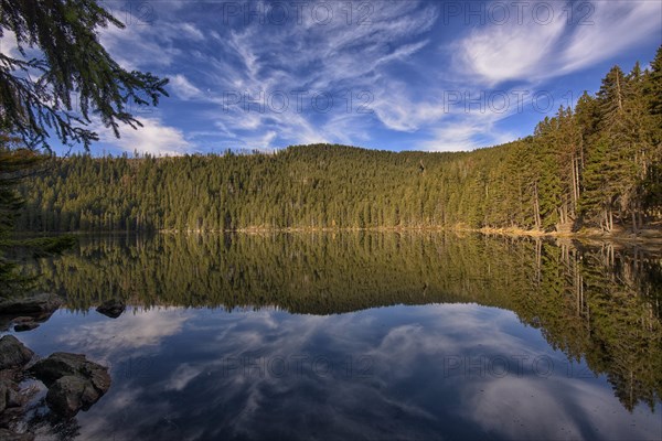 Reflection with clouds in Certovo jezero lake in fall