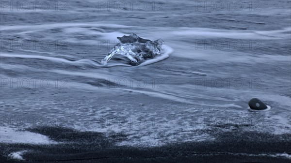 Stranded iceberg beside the lava of Breidarsandur