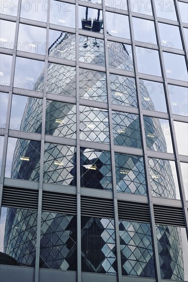 The Gherkin or 30 St Mary Axe building reflected in the glass of an adjacent office block