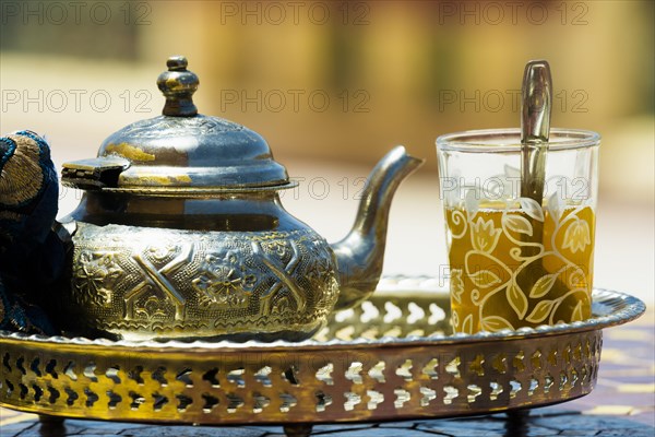Glass with mint tea and silver teapot