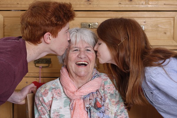 Grandmother getting a kiss from her grandchildren