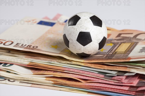 Football lying on pile of money