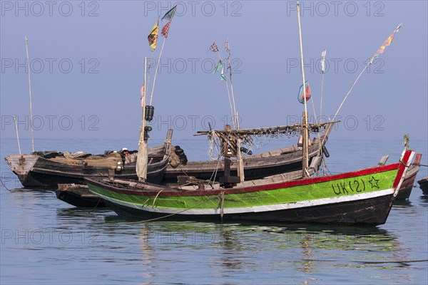 Colourful fishing boats in the sea off the beach of the fishing village of Ngapali