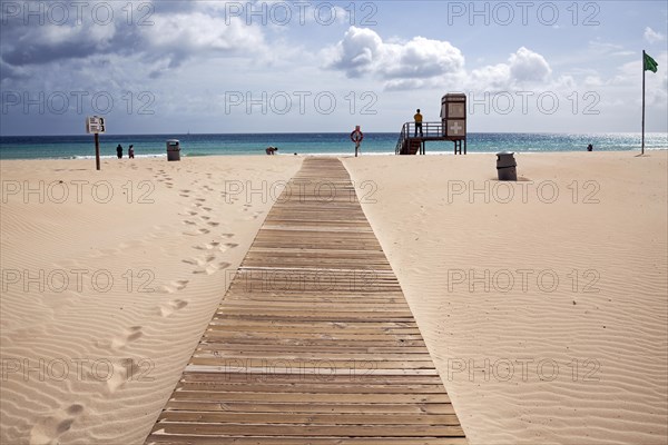 Boardwalk over the sand dunes to the sea with lifesaver station