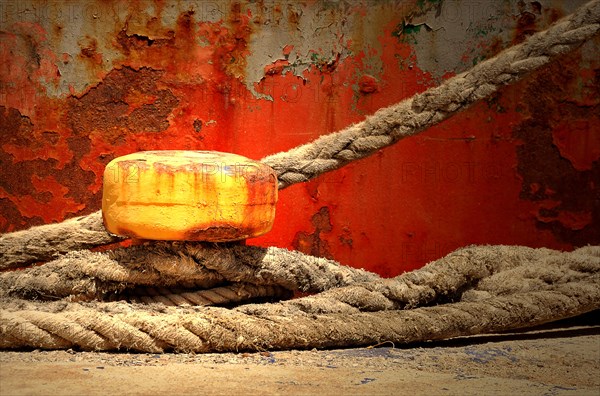 Yellow bollard with ropes wrapped around