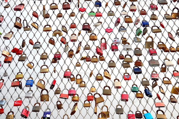 Love locks hanging on metal grid