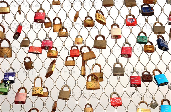 Love locks hanging on metal grid