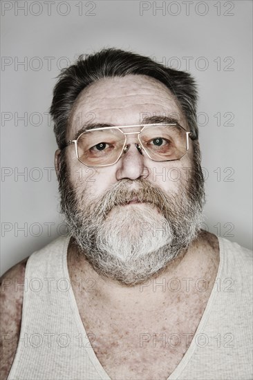 Senior with beard and glasses in his undershirt