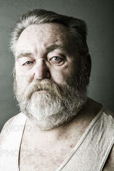 Obese senior with a full beard and in his undershirt