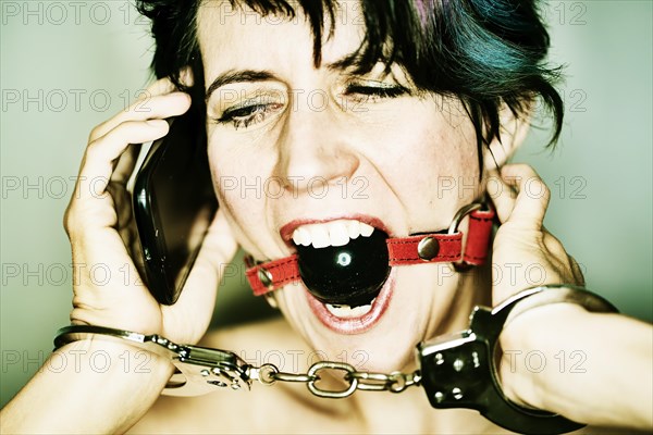 Gagged woman trying to use a smartphone