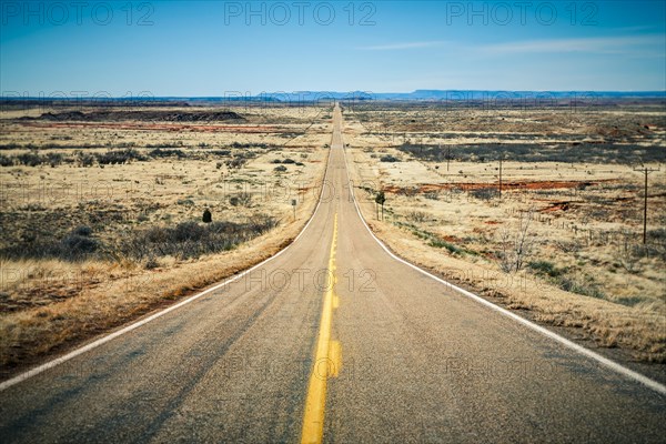 Long straight desert road stretching into the distance to the horizon