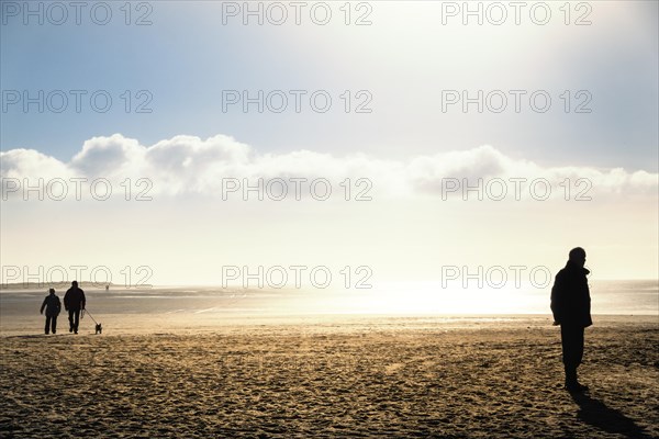 People walking on the beach in autumn