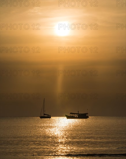 Two boats in sea at sunset