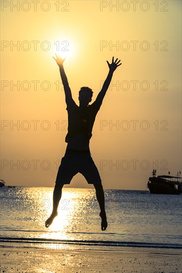 Young man jumping on beach