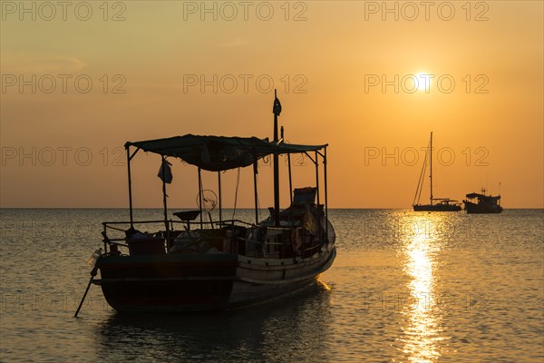 Fishing boat in sea at sunset