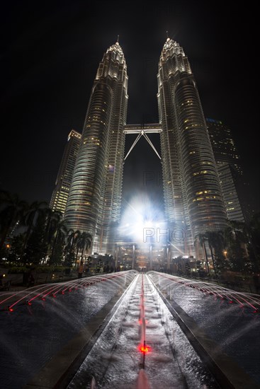 Fountain in front of illuminated Petronas Twin Towers at night