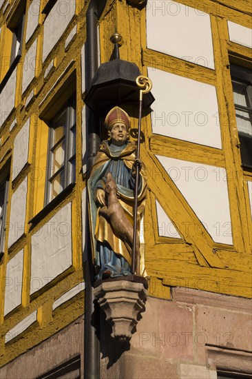 Figure Saint Giles on an old half-timbered house in the Weissgerbergasse