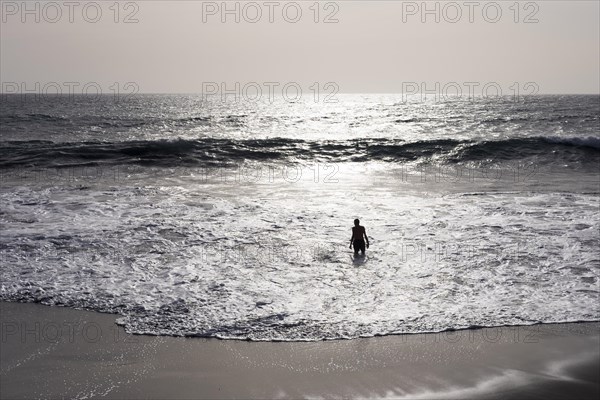 Man standing on breakwater at the beach of La Playa