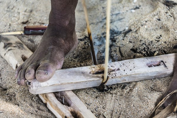 Man of the Orang Asil tribe starting a fire with wood