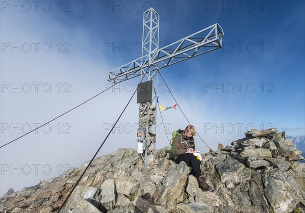 Hiker writing in the logbook at the summit