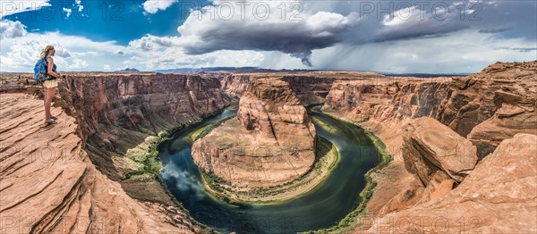 Tourist on a rock overlooking the Horseshoe Bend