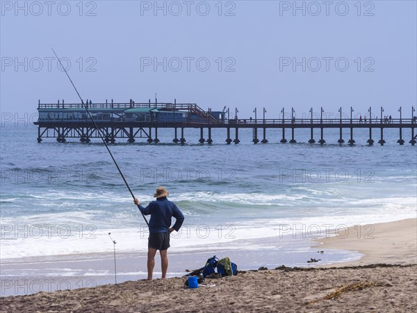 Angler standing on the beach fishing