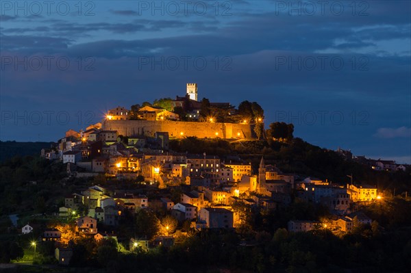 Idyllic village on hilltop with Venetian fortress at night