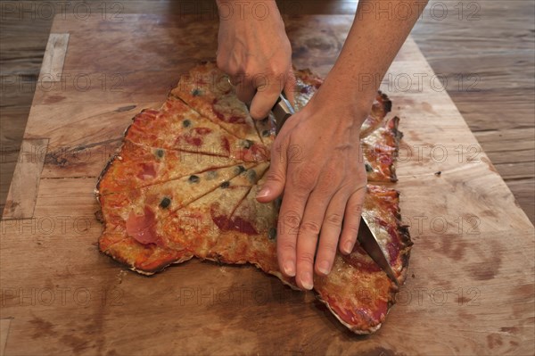 Stonebaked pizza being cut on a board