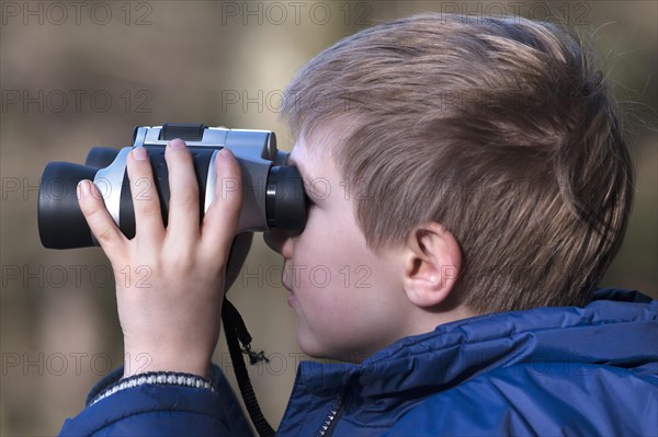 Boy looking through binoculars