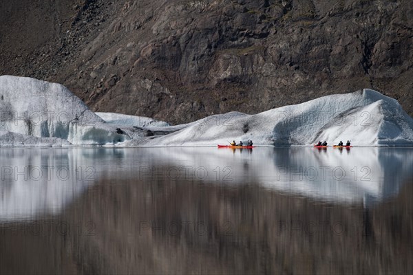 Kayakers in front of icebergs