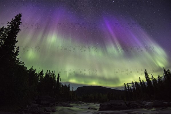 Northern Lights or Aurora Borealis over the river Gamajahka or Kamajakka