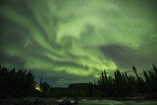 Northern Lights or Aurora Borealis over the river Gamajahka or Kamajakka