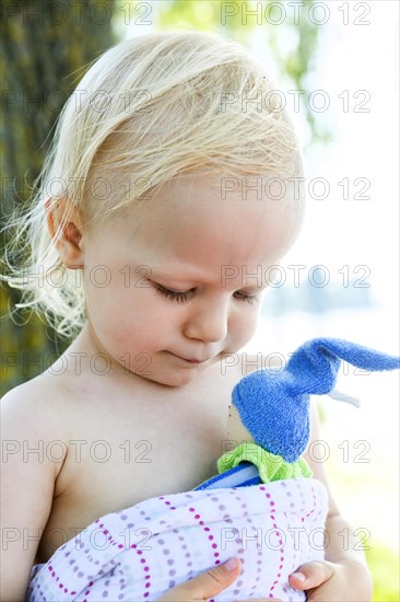 Toddler holding a small doll