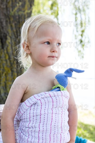 Toddler with a wrap and a small doll