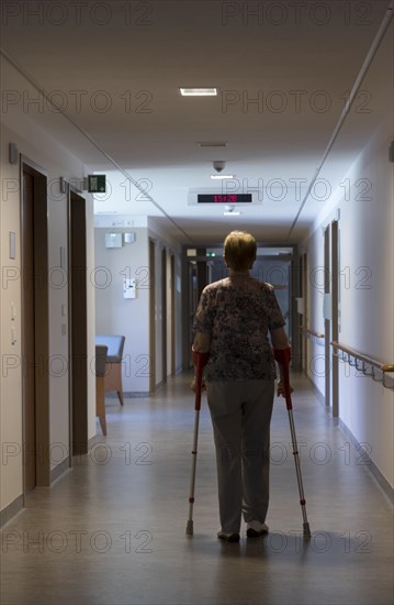 Elderly woman walking with crutches