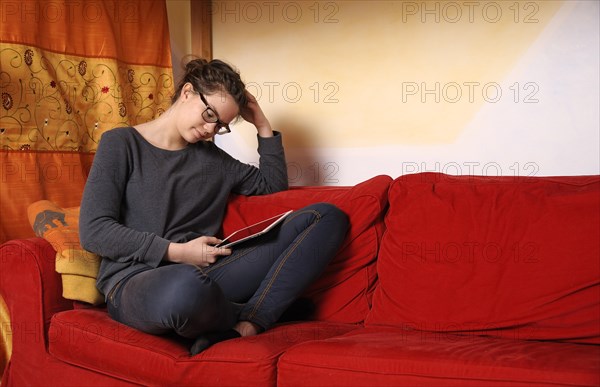 Teenager sitting with an i-Pad on a couch