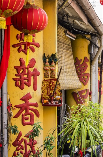 Chinese characters on a column and oblation in the district of Kampung Dua