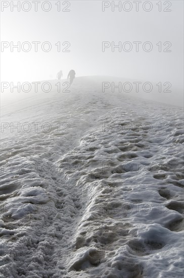 Climbers fading away in the fog