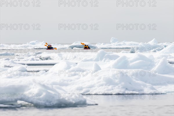 Canoeists amid icebergs on the sea ice edge of North Spitsbergen