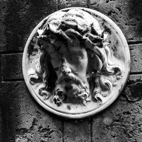 Face of Jesus on a gravestone in the cemetery next to the ghost church of Lukova