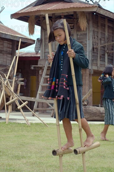 Tai Dam children walking on bamboo stilts