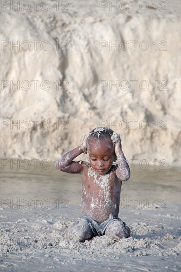 Little Creole boy playing on the beach