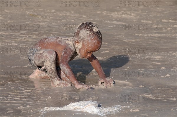 Little Creole boy playing on the beach