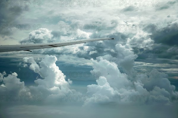 Dramatic cloud formations and the wing of a Boeing 777-300
