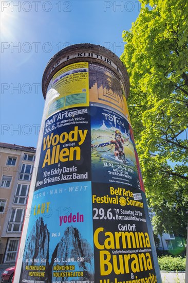 Old advertising pillar with advertising posters for culture