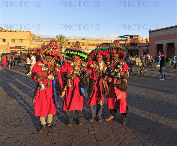 Guerrab or water carriers in traditional clothes with water bags and brass bowls on the jugglers square