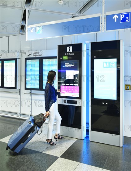 Woman with luggage at the InfoGate