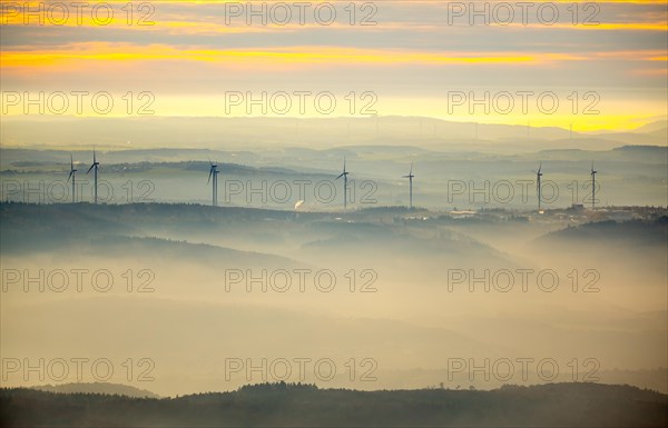 View over the mountains with wind turbines and fog